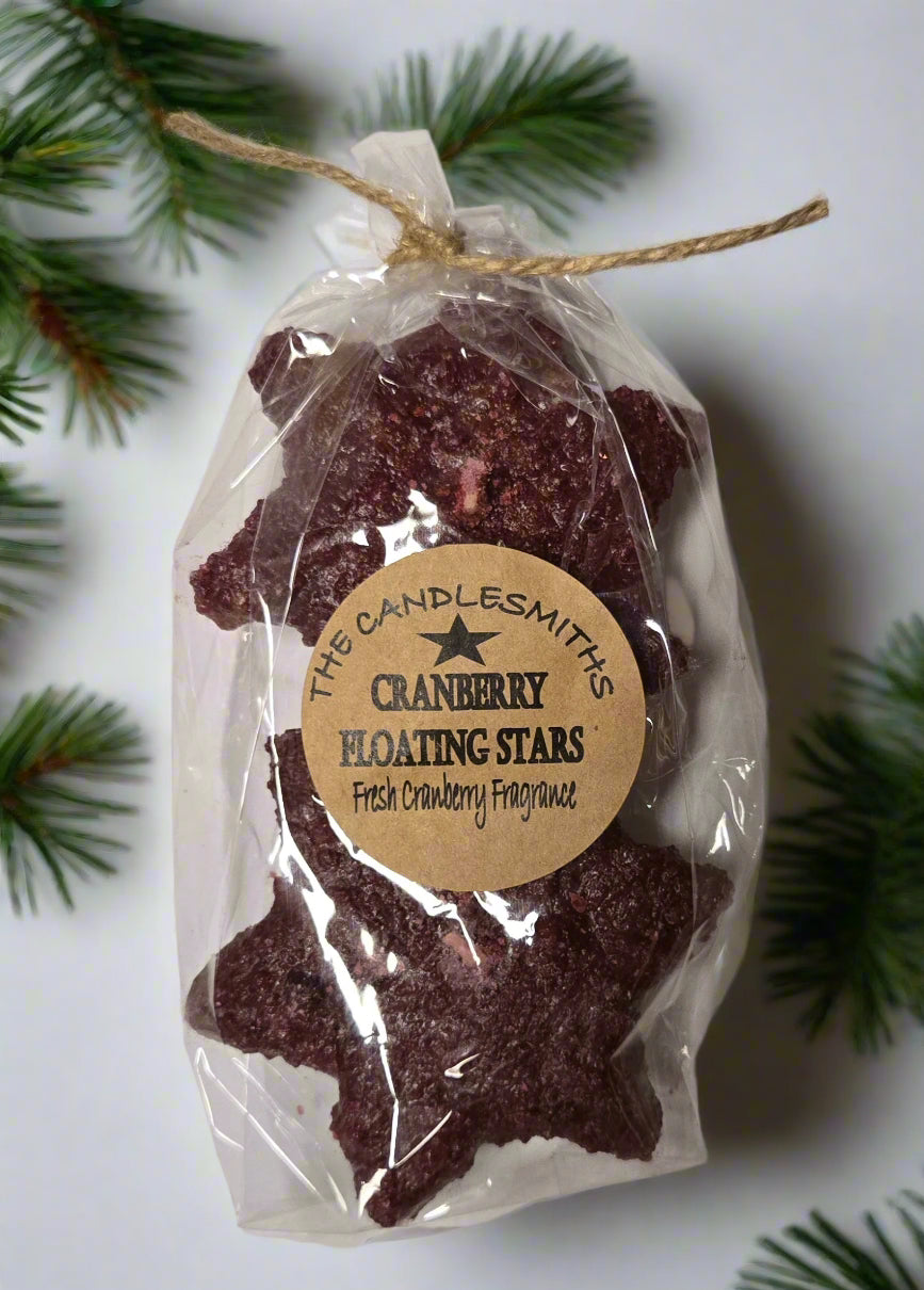 Two packs of floating candles shaped like stars and colored red, packaged in clear plastic with a label that reads 'CRANBERRY FLOATING STARS'.