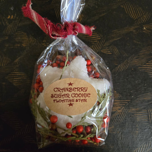 Packaged cranberry sugar cookie floating star with decorative label on a textured surface