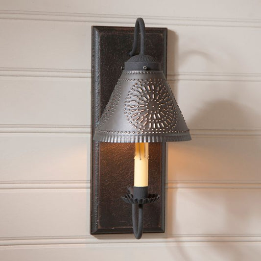 Decorative wall sconce with intricate design on a neutral wall.
