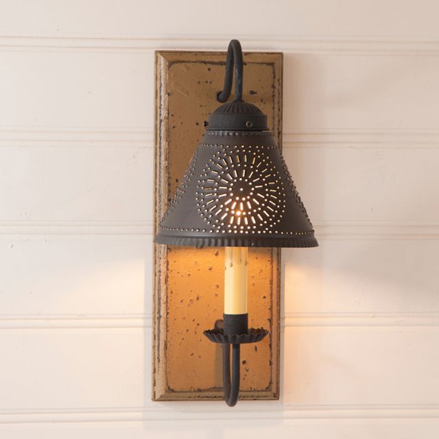 Decorative wall sconce with rustic design on a wooden panel.