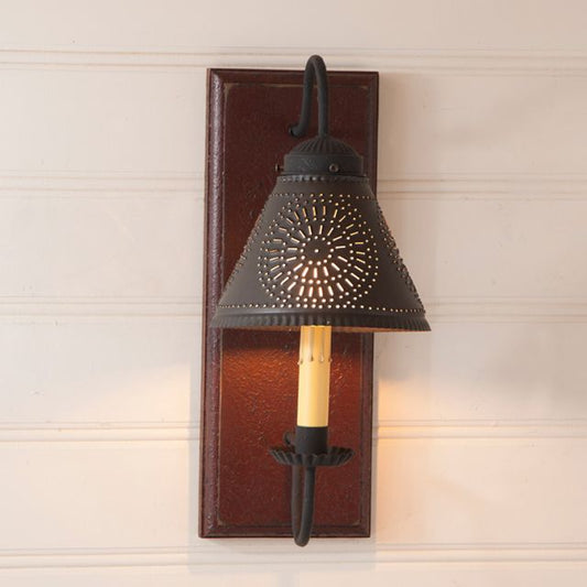 Decorative wall sconce with black metal shade and wooden base on a light-colored wall.