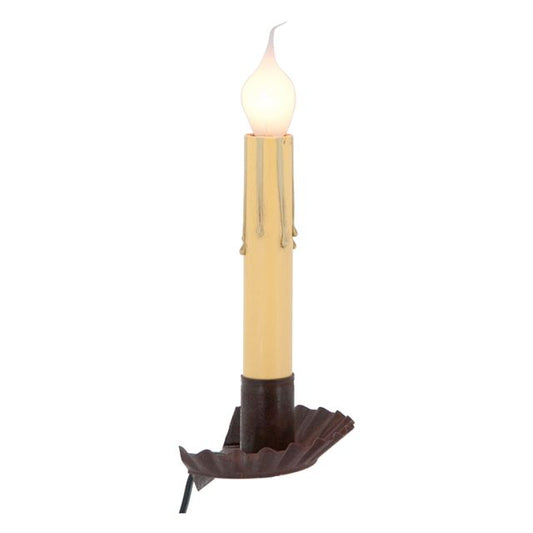 A rustic tin window sill light with a visible wax candle top and a brown base, designed to be placed on a window sill.