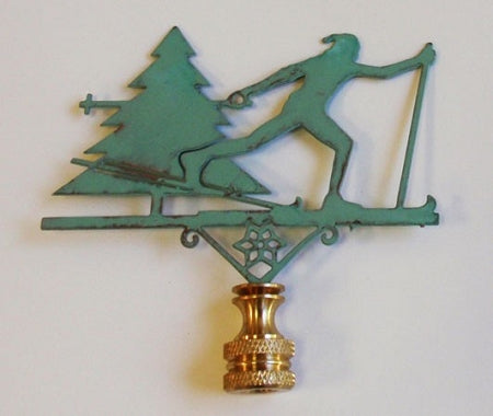 Copper verdigris finish lamp finial with cross country skier next to a tree