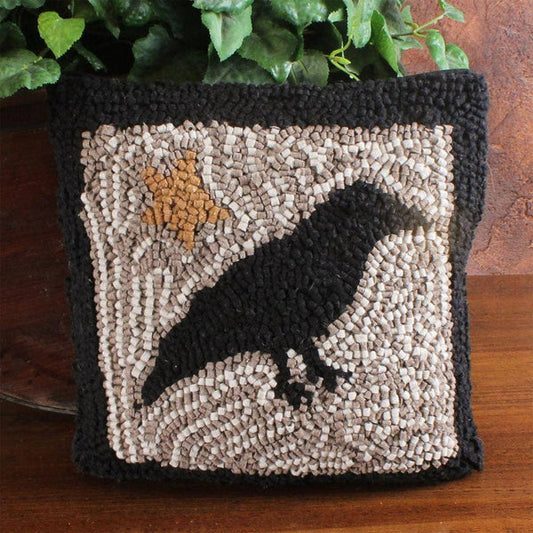 Decorative pillow with a crow silhouette and star design on a textured background.