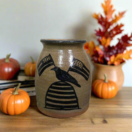 Ceramic vase with black abstract design on a wooden surface