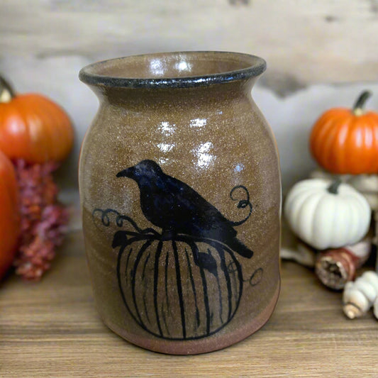 Ceramic vase with a black bird design on a neutral background