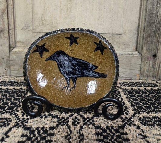 Small oval stoneware plate with a crow and three stars above