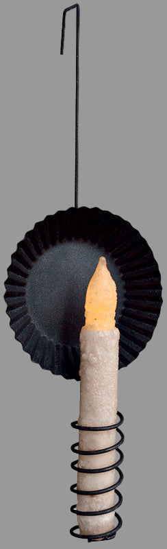 Decorative candle with black paper holder on a white background