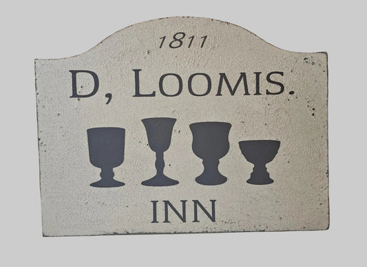 Decorative sign with 'D. Loomis Inn' and vintage design elements on a light background