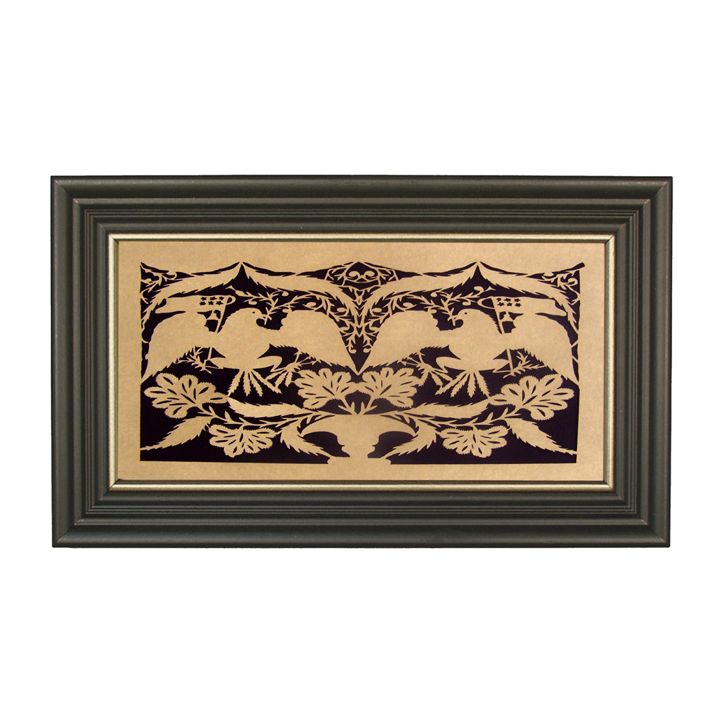 A framed paper cutting artwork featuring a geometric pattern with eagle silhouettes and floral elements, set against a black background with gold frame.