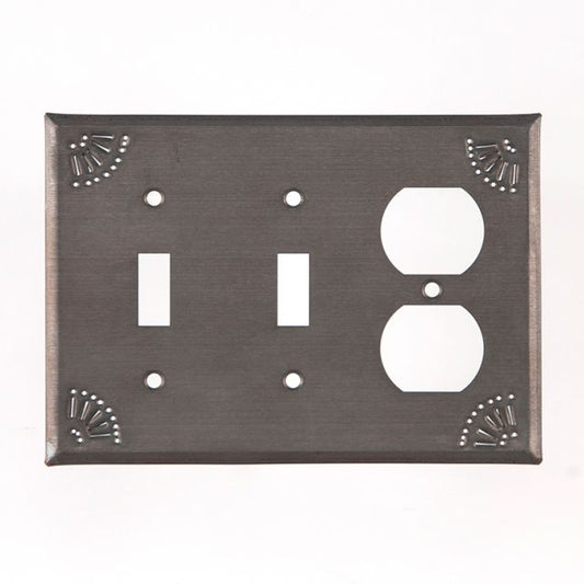 A black tin double switch and outlet cover with chisel marks around the edge.