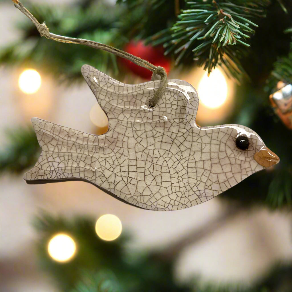 Decorative dove ornament on a Christmas tree with blurred lights in the background