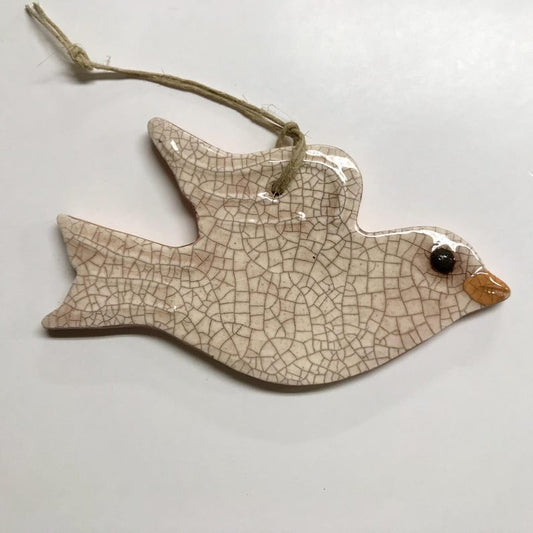 Pottery ornament in the shape of a white dove with a string to hang