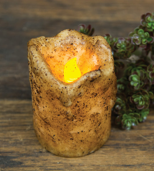 4" dripped pillar burnt ivory pillar candle on wood surface with greenery
