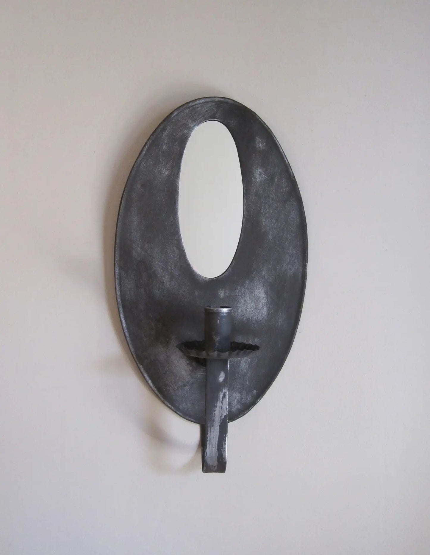 Decorative wall sconce with a black finish on a plain wall.