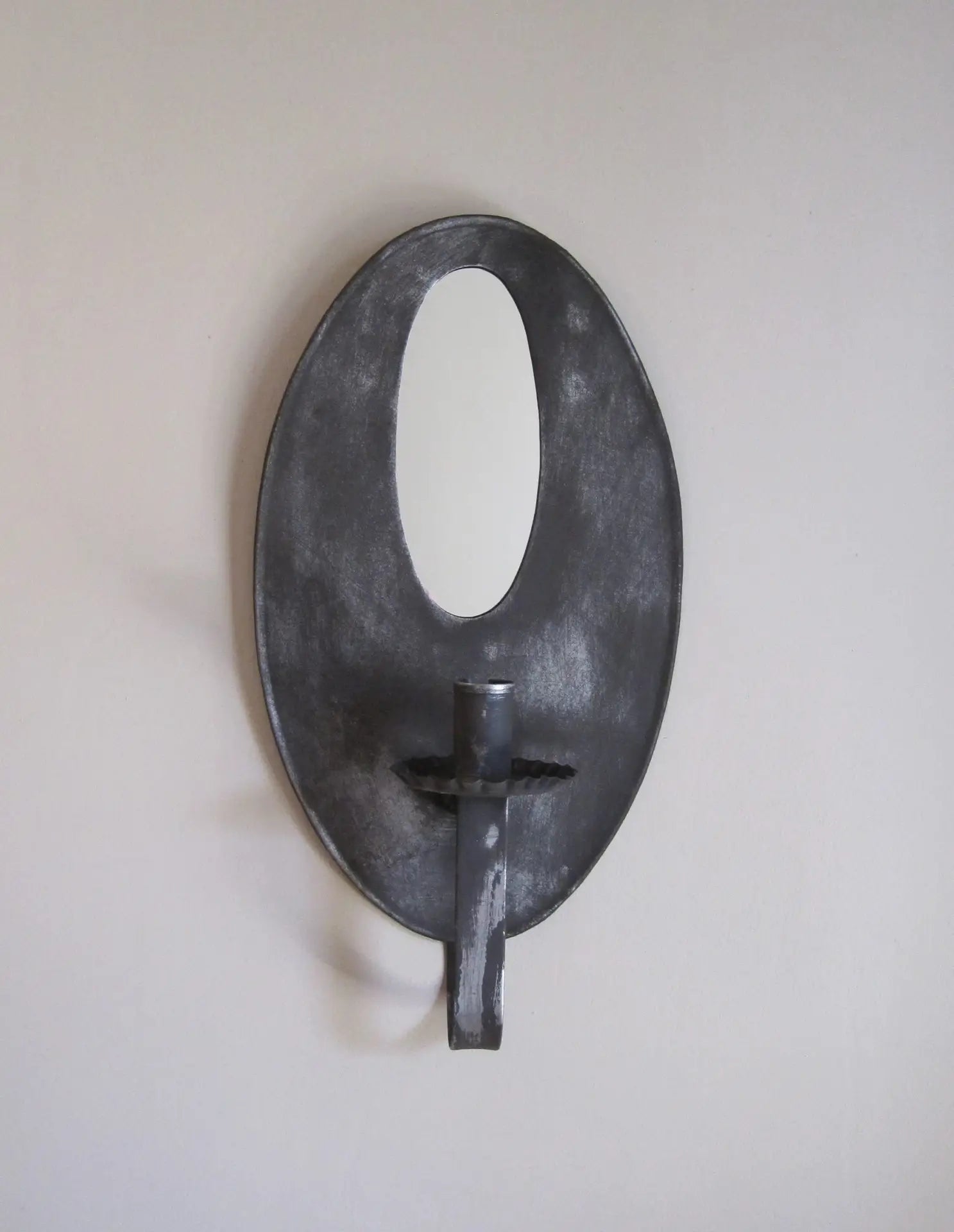 Decorative wall sconce with a black finish on a plain wall.