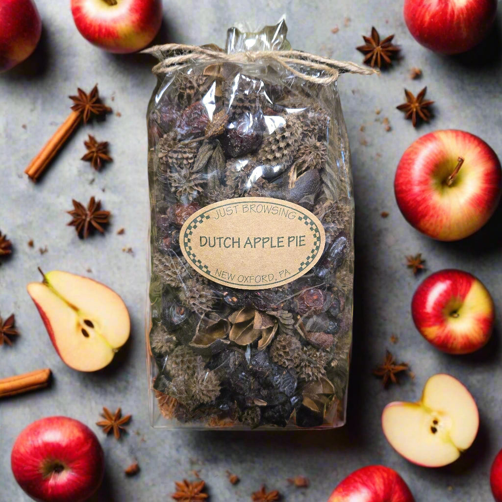 Bag of Dutch Apple Pie spice mix with apples and cinnamon sticks on a gray surface