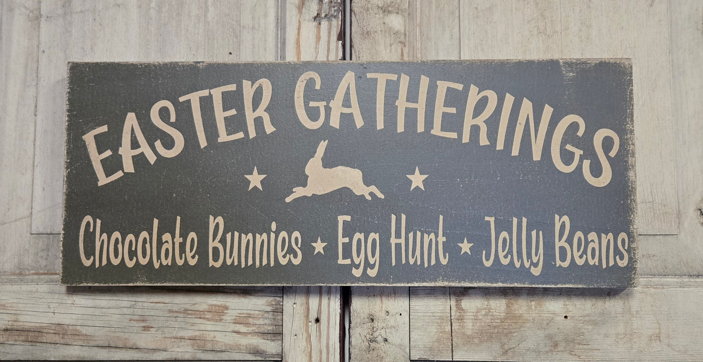 Wooden sign with 'Easter Gatherings' text and bunny illustration on a wooden background