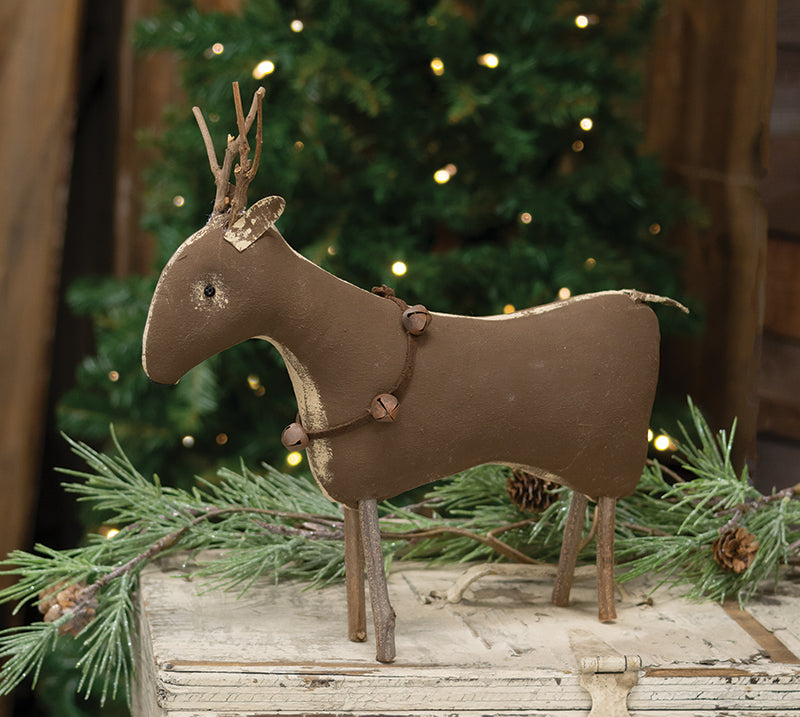 Decorative reindeer figure with a Christmas tree in the background