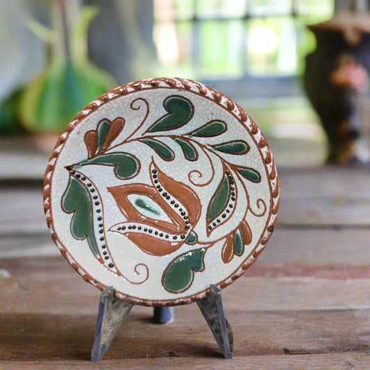 Small round redware plate with an intricate tulip design