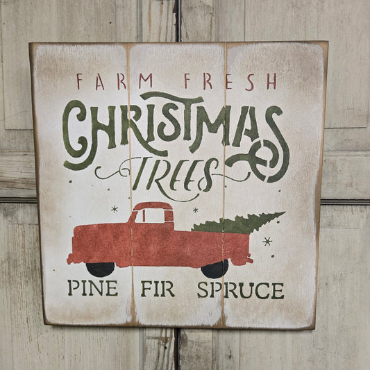 A square sign with a rustic design featuring the text 'Farm Fresh Christmas Trees' and an illustration of a red pickup truck with a Christmas tree in the bed.