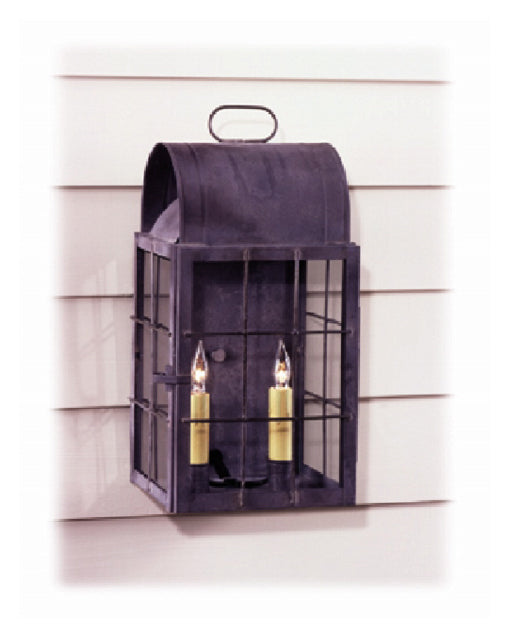 A black copper wall-mounted lantern with a pewter finish, featuring two light bulbs, against a white exterior wall.