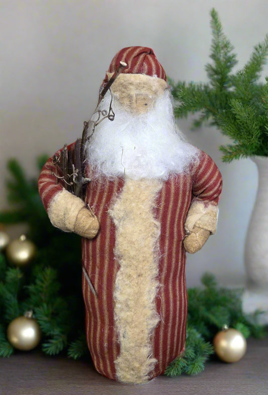 Decorative figure of a Santa Claus in a striped red and white suit with a white beard, surrounded by greenery.