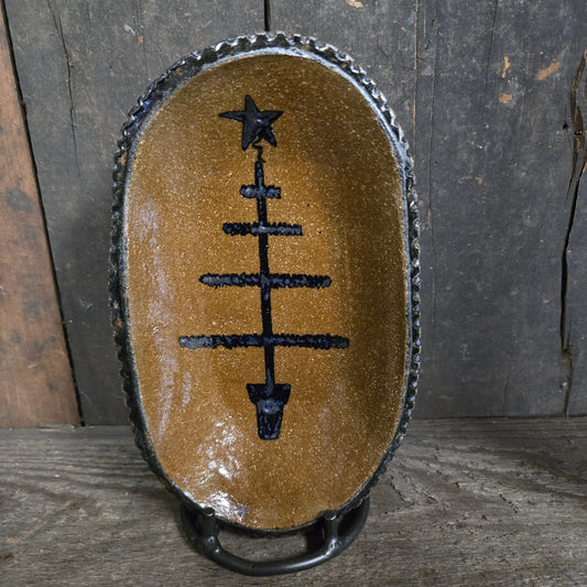 Stoneware plate with feather tree design on wood background.