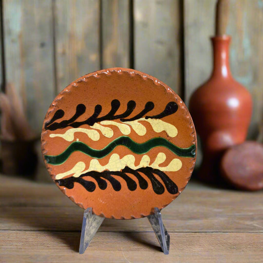 Small round slipware plate with brown, green and yellow hues