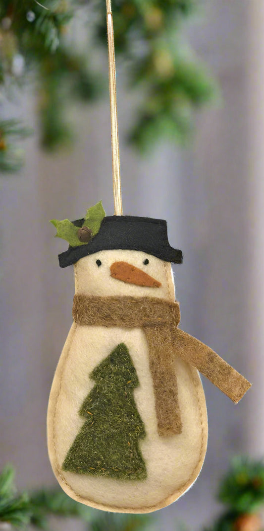 Felt snowman ornament with a tree, scarf, and hat on a white background