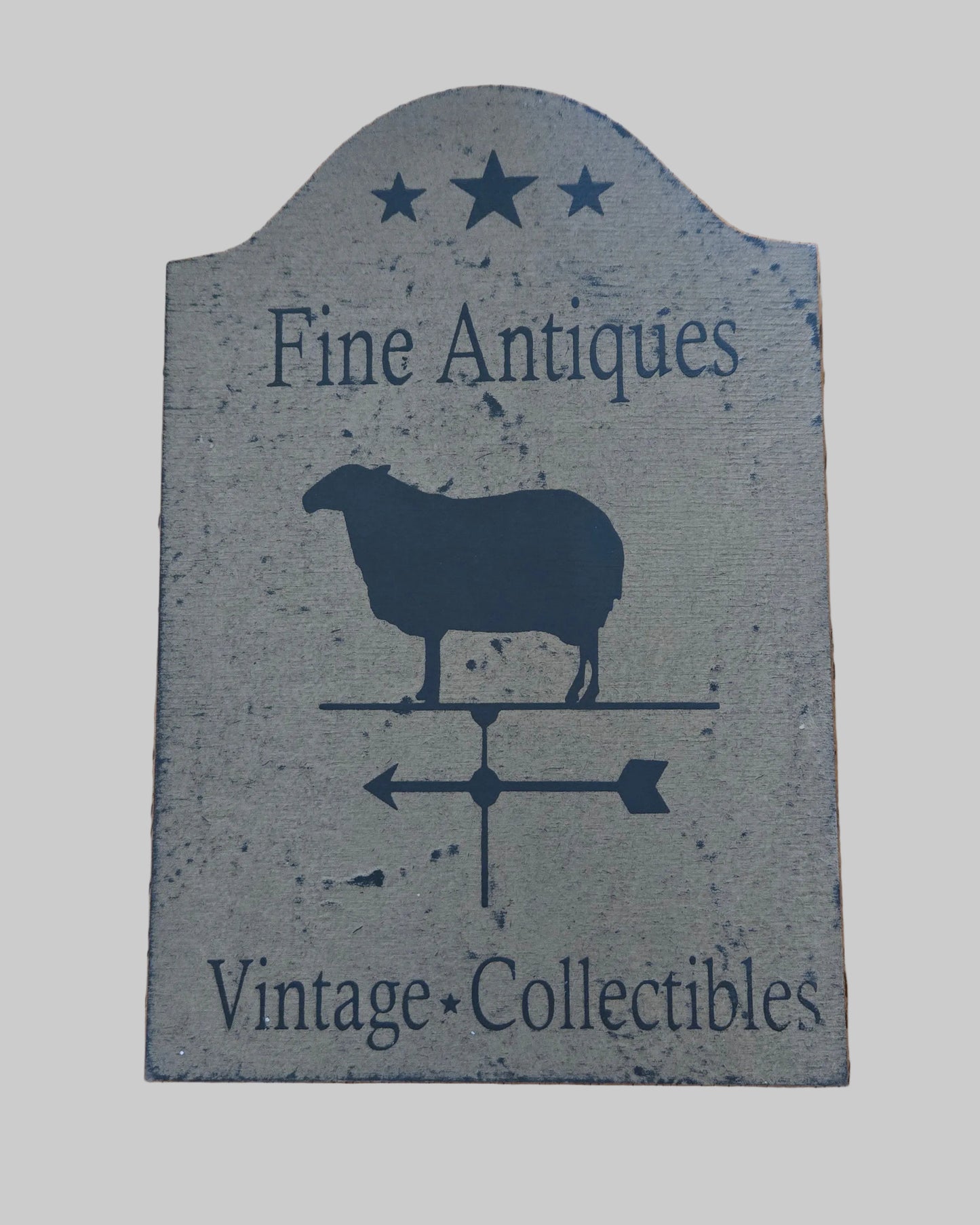 Decorative sign with a sheep silhouette and text on a wooden surface