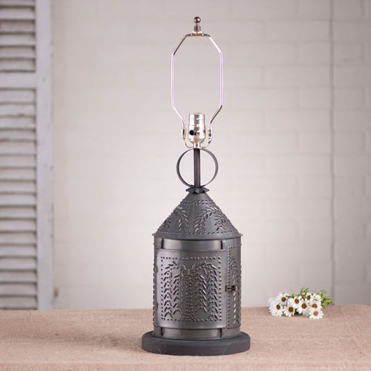 Decorative metal lantern with willow tree piercing on a table with a neutral background.