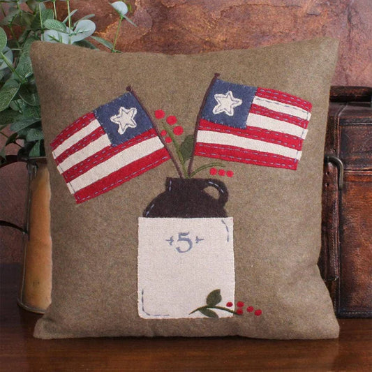 Decorative pillow with American flags and a vase on a wooden surface
