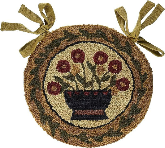 A round chair pad with a floral basket design, featuring multicolored flowers in a brown background, with a hooked chair pad made of a textural material, adorned with a dark green border.
