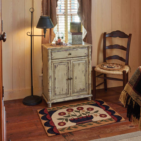 Flower basket hooked rug surrounded by a floor light, chair and dresser