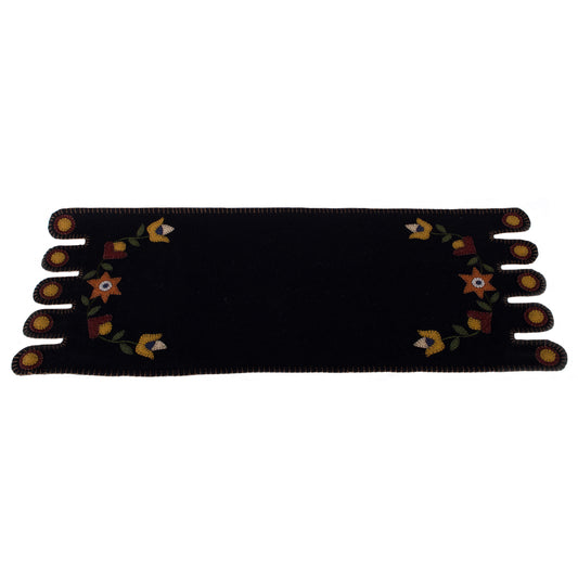 A black table runner with a floral design in the center, displayed on a neutral background.