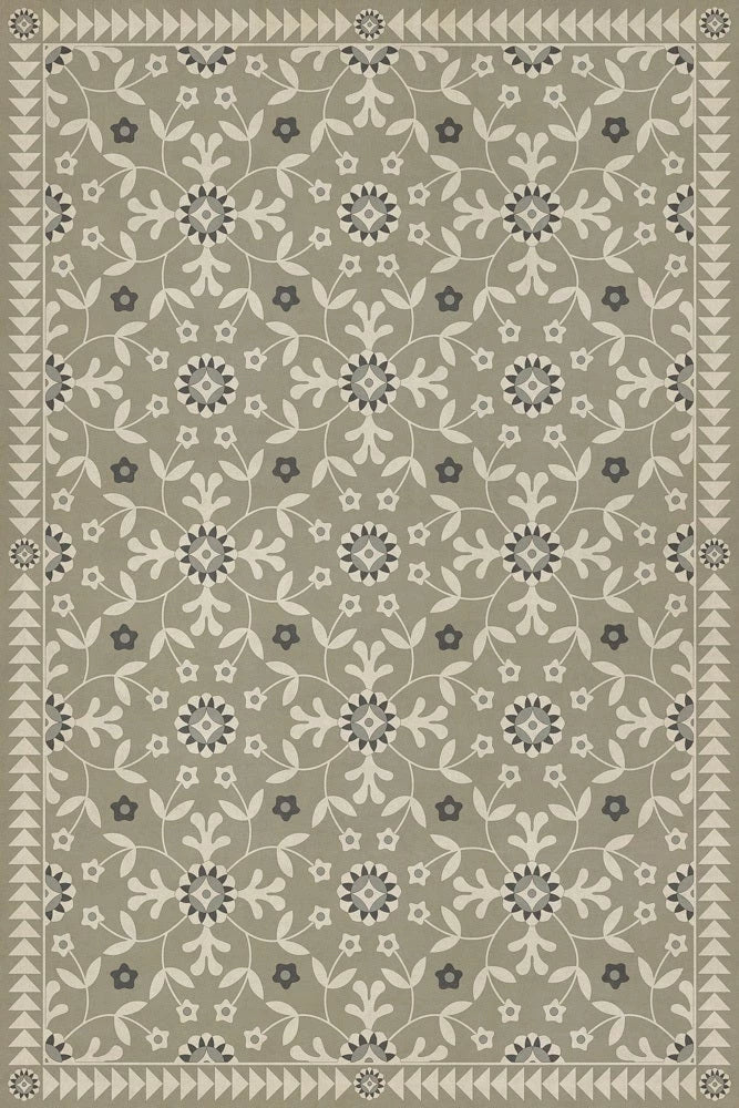 A vinyl floor cloth with a green and beige floral pattern.