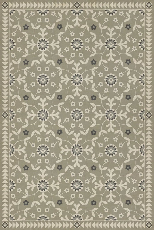 A vinyl floor cloth with a green and beige floral pattern.