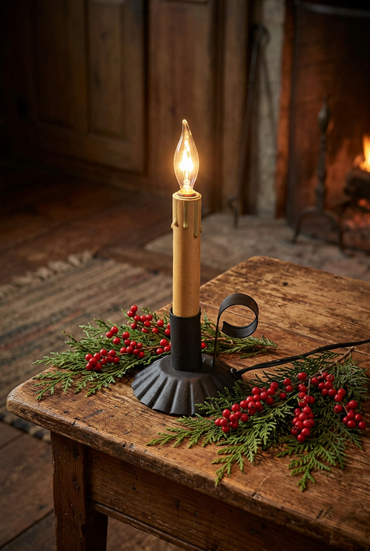 Textured black accent light on primitive wooden table with fresh cedar greens and berries.