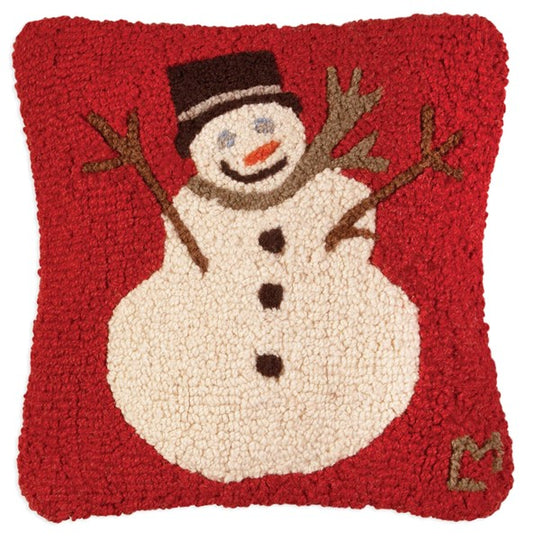 A square-shaped hooked wool pillow with a red background featuring a snowman design and a color-coordinated velveteen backing.