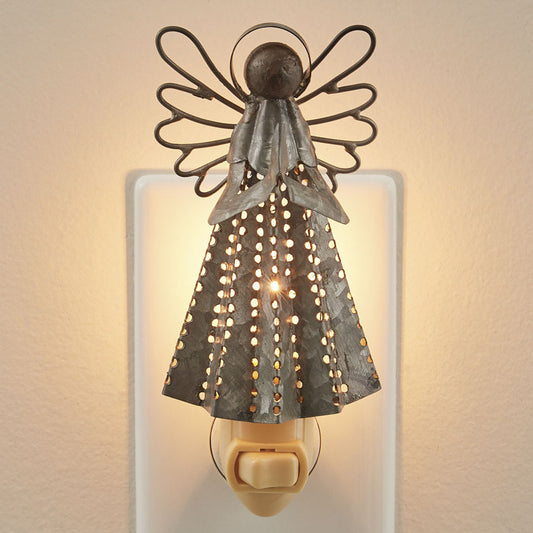 A silver galvanized angel night light mounted on a white wall bracket, emitting a warm light.