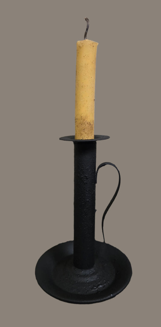 A textured black candle holder with a single taper candle, set against a plain background.