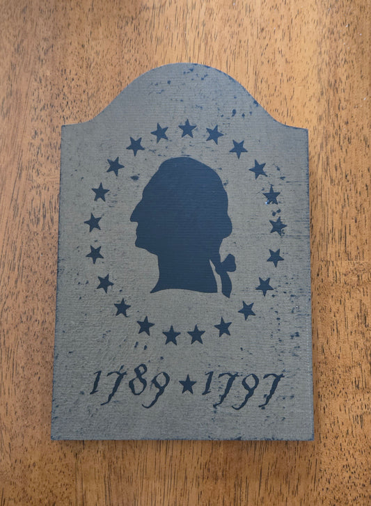 Decorative plaque with a silhouette and stars on a wooden surface