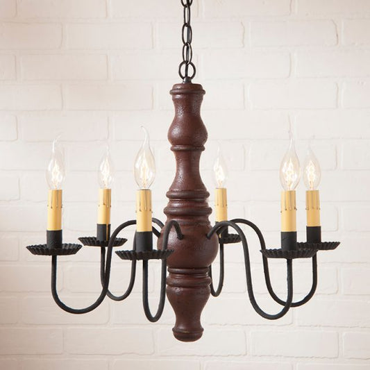 Wooden chandelier with six candle-style lights on a white brick wall background