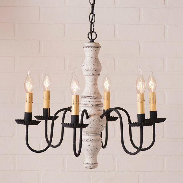Chandelier with black and white design against a white brick wall