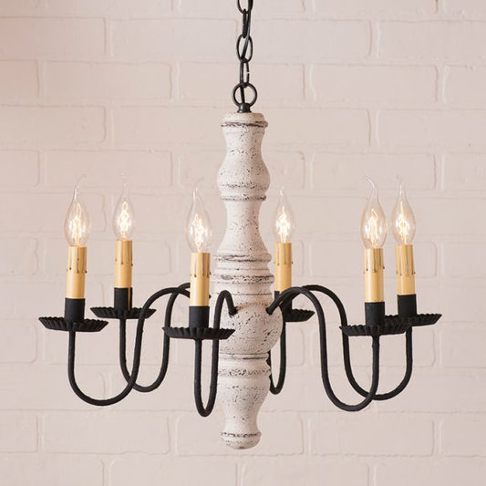Chandelier with black and white design against a white brick wall