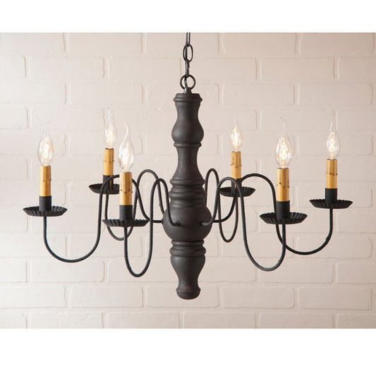 Black chandelier with six candle-style lights on a white brick wall background