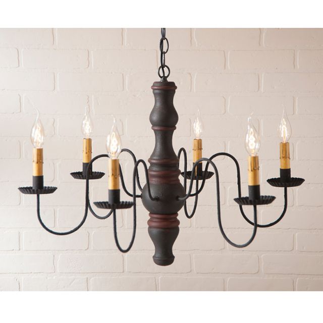 Wooden chandelier with six candle-style lights on a white brick wall background