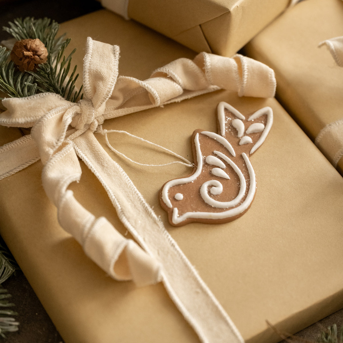 Gift wrapped in brown paper with a decorative bow and gingerbread man design.