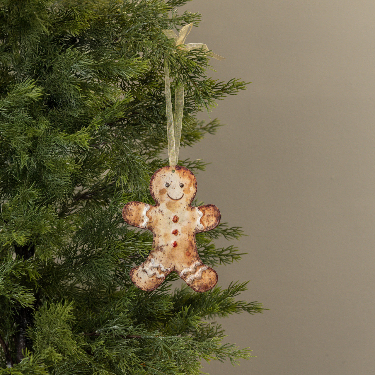 Gingerbread man ornament hanging on a Christmas tree